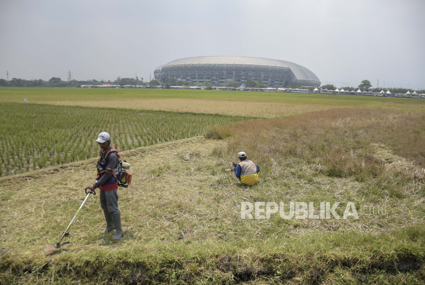 Pekerja memotong rumput di lahan yang akan dijadikan tempat pembuangan sampah (TPS) darurat di kawasan Gedebage, Kota Bandung, Jawa Barat, Kamis (7/9/2023). 