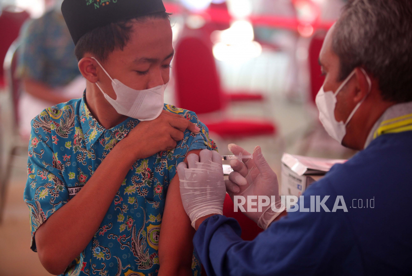 Masih Ada Siswa Anggap Vaksinasi Bertentangan dengan Agama. Petugas kesehatan menyuntikan vaksin COVID-19 kepada santri di kompleks Pesantren Matholiúl Anwar, Lamongan, Jawa Timur,  Jumat (8/10/2021). Otoritas Jasa Keuangan bersama PT Bursa Efek Indonesia (BEI), PT Kliring Penjaminan Efek Indonesia (KPEI), dan PT Kustodian Sentral Efek Indonesia (KSEI) menyelenggarakan rangkaian kegiatan sosial dan vaksinasi yang bertujuan untuk membantu masyarakat yang membutuhkan bantuan di tengah kondisi pandemi dan juga dalam rangka peringatan 44 tahun diaktifkannya kembali Pasar Modal Indonesia. 