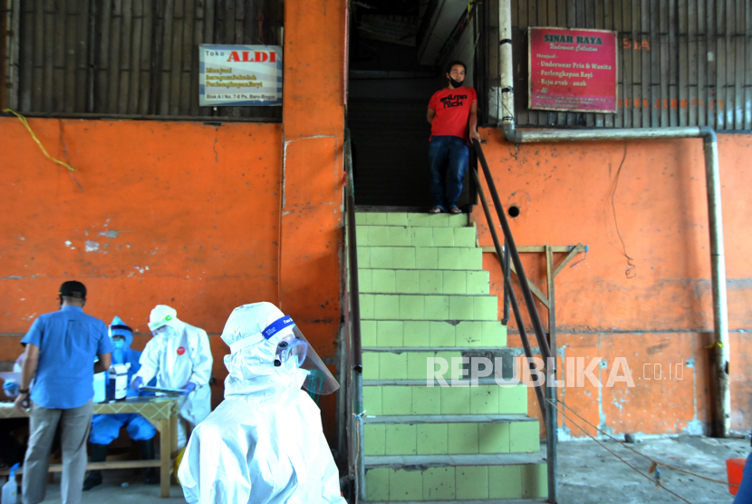 Petugas medis dari Dinas Kesehatan Kota Bogor melakukan tes swab kepada pedagang di Pasar Baru Bogor, Jawa Barat, Selasa (12/5/2020). Tes swab terhadap 16 pegawai Perumda Pasar Pakuan Jaya Kota Bogor dan pedagang Pasar Baru Bogor tersebut dilakukan untuk menelusuri kontak langsung dengan seorang pedagang yang terkonfirmasi positif virus Corona (COVID-19) di pasar tersebut