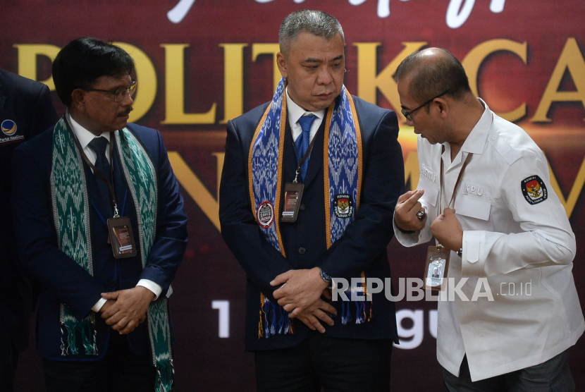 Ketua KPU Hasyim Asyari (kanan) berbincang dengan Wakil Ketua Umum Partai Nasdem Ahmad Ali (tengah) dan Sekjen Partai Nasdem Johnny G Plate (kiri) pada pendaftaran partai politik calon peserta Pemilu 2024 di kantor KPU, Jakarta, Senin (1/8/2022). 