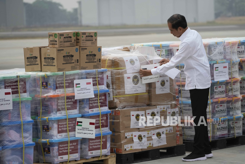 Presiden Indonesia Joko Widodo menempelkan stiker pada perbekalan bantuan saat pemeriksaan bantuan untuk warga Palestina.