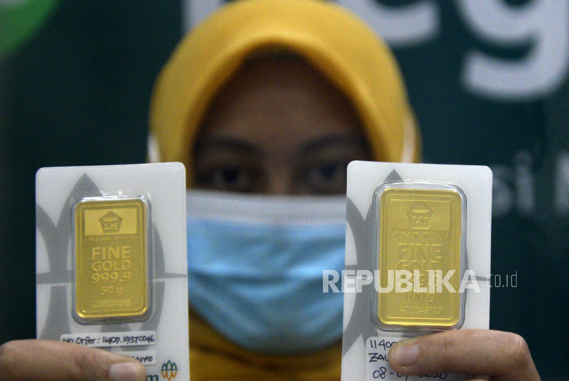Seorang karyawan menunjukkan kepingan emas di kantor Pegadaian Makassar, Sulawesi Selatan, Kamis (15/10/2020). 