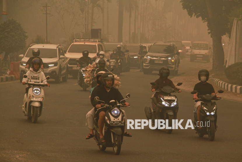 Sejumlah pengendara motor melintasi Bundaran Burung saat kabut asap di Palangka Raya, Kalimantan Tengah, Selasa (29/9/2026). Berdasarkan pantauan aplikasi ISPUnet, kualitas udara di Kota Palangka Raya pada Selasa (29/9) pukul 16.00 WIB masuk dalam kategori berbahaya dengan nilai indeks standar pencemaran udara mencapai angka 1108. 
