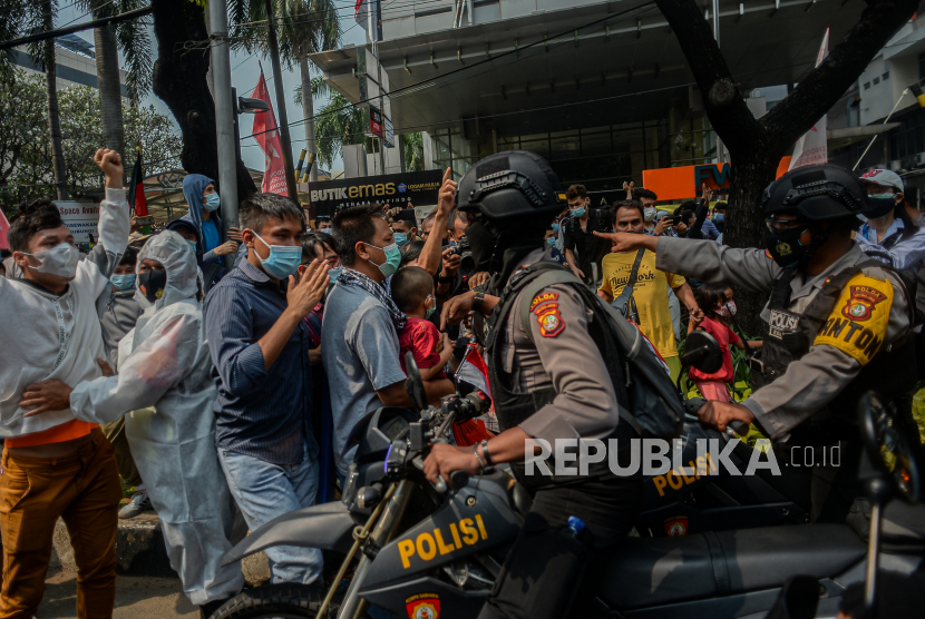 Petugas kepolisian membubarkan massa dari Pencari Suaka asal Afghanistan saat melakukan aksi di depan kantor Komisi Tinggi PBB untuk Pengungsi (UNHCR), Kebon Sirih, Jakarta, Selasa (24/8). Dalam aksinya, massa menuntut kejelasan kepada UNHCR terakit status penempatan pencari suaka di negara ketiga. Aksi tersebut dibubarkan aparat kepolisian untuk menghindari kerumunan pada masa PPKM level 3 di Jakarta. Republika/Thoudy Badai