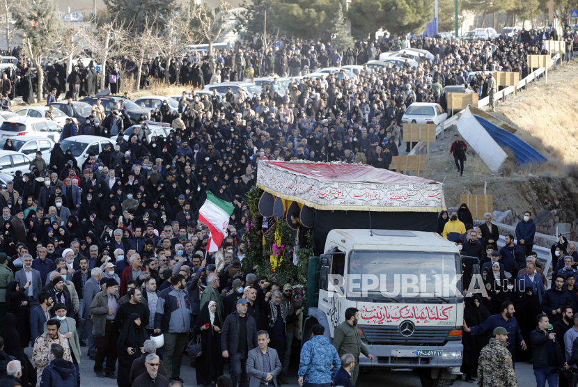   Orang-orang berjalan di samping truk yang membawa peti mati komandan Korps Pengawal Revolusi Islam Iran (IRGC) Sadegh Omidzadeh dan Mohammad Amin Samadi saat upacara pemakaman di Teheran, Iran. 