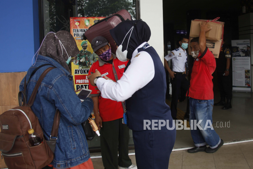 Petugas memeriksa sertifikat vaksin COVID-19 dan membagikan masker bagi penumpang yang tiba di Terminal Tirtonadi Solo, Jawa Tengah, Rabu (13/4/2022). BNPB memantau prokes para pemudik di setiap pos pemantauan.