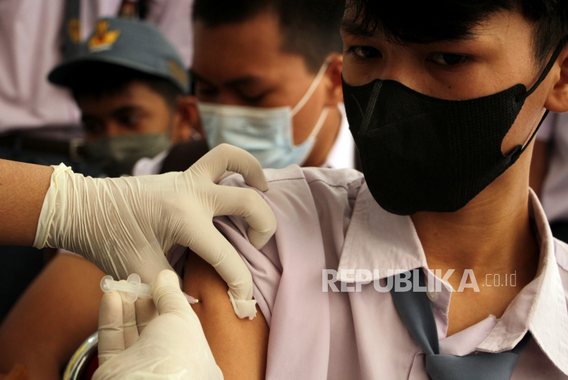 Petugas kesehatan menyuntikkan vaksin COVID-19 kepada siswa di SMA 4 Makassar di Makassar, Sulawesi Selatan, Senin (25/10/2021). Vaksinasi tersebut untuk membentuk kekebalan kelompok (herd immunity) di lingkungan sekolah sebagai upaya pengendalian COVID-19 saat pelaksanaan pembelajaran tatap muka terbatas di daerah itu serta membantu pemerintah dalam memenuhi capaian vaksinasi nasional sebesar 70 persen dari target sasaran sebanyak 208.265.720 orang. 