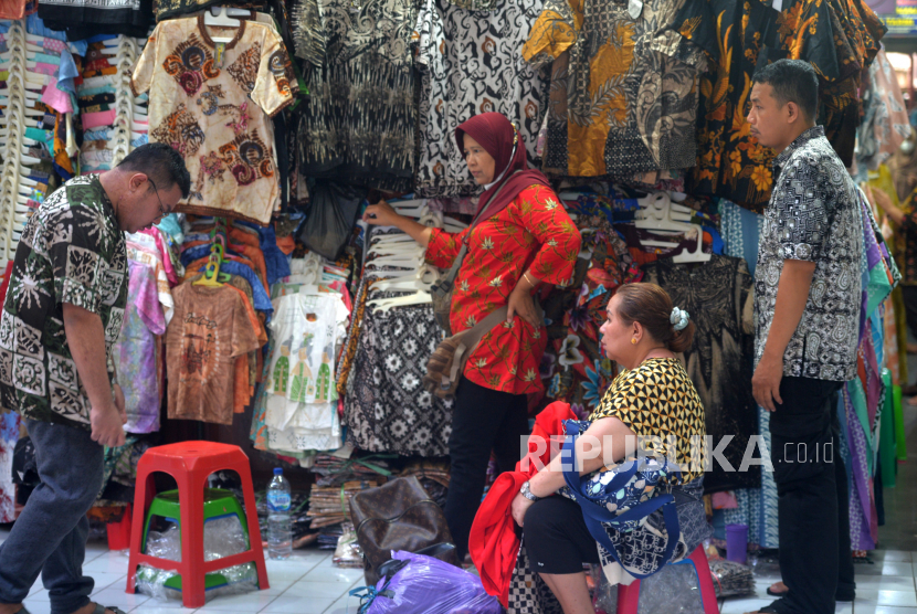 Pengunjung mencoba pakaian batik saat berbelanja di los penjualan batik, Pasar Beringharjo Bagian Barat Yogyakarta, Jumat (28/4/2023).