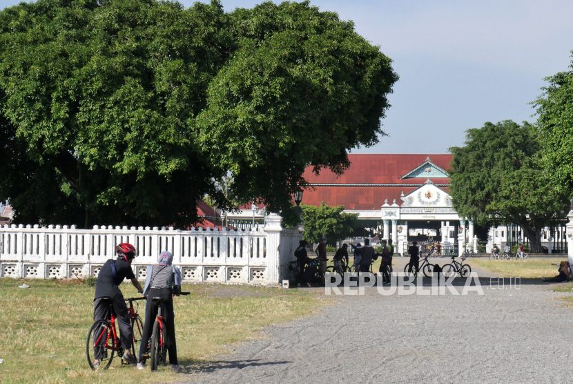 Warga beristirahat saat bersepeda di Alun-alun Utara Yogyakarta. 