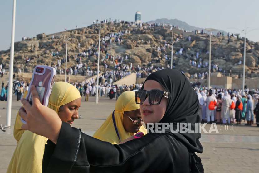 Jamaah umrah asal Indonesia berswafoto dengan latar belakang Jabal Rahmah di Mekkah, Arab Saudi. Pemerintah Arab Saudi memutuskan untuk menurunkan biaya umrah tahun 2023 bagi jamaah asing. 
