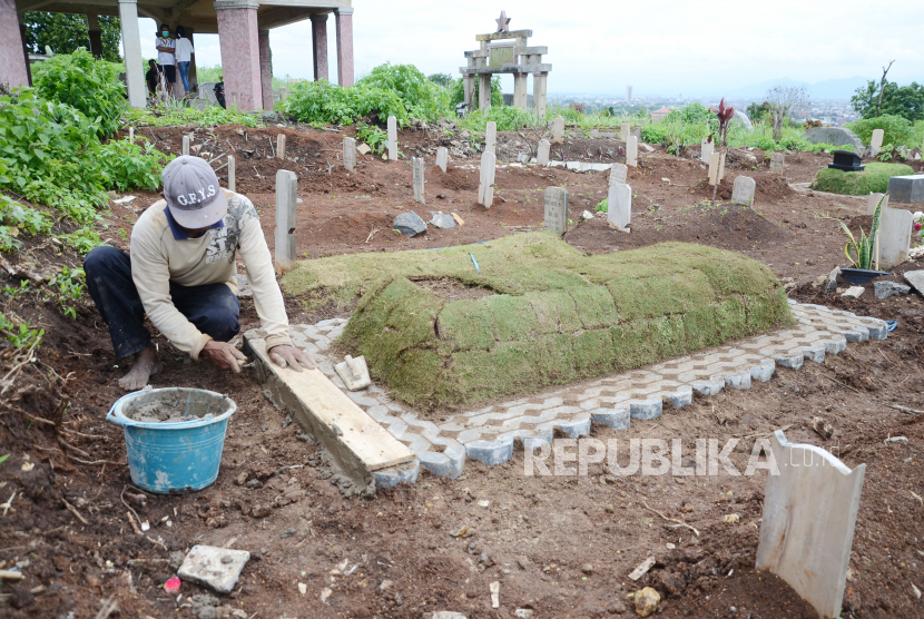 Warga menghiasi sebuah kuburan di Tempat Pemakaman khusus Covid-19 Cikadut, Kota Bandung, Rabu (27/1). Jumlah kuburan di tempat tersebut dari hari ke hari terus bertambah.
