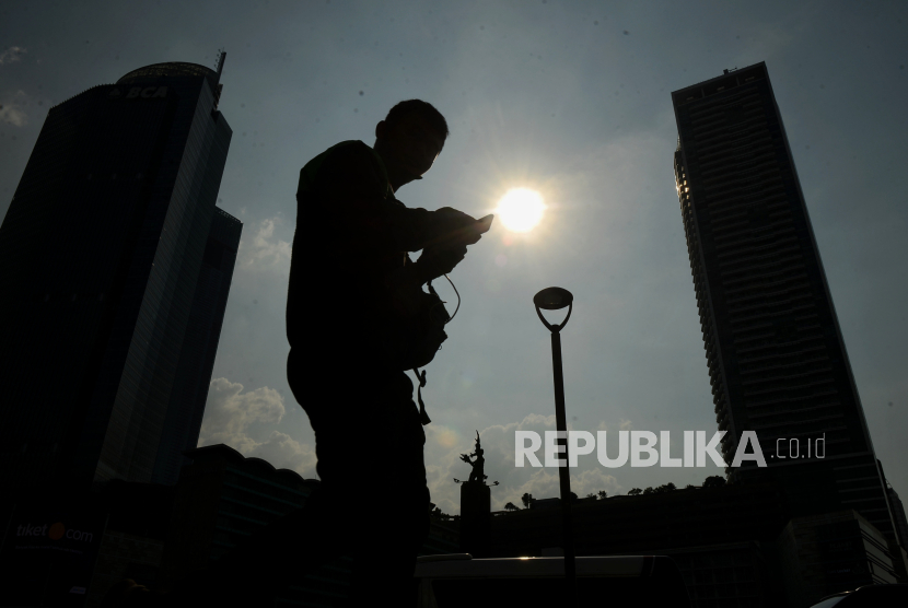 Perkeja beraktivitas dibawahi terik matahari di kawasan Bundaran HI, Jakarta, Senin (18/12/2023). 