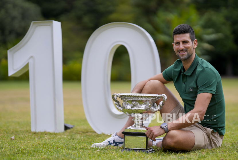 Novak Djokovic dari Serbia berpose dengan Norman Brookes Challenge Cup di taman Government House setelah mengalahkan Stefanos Tsitsipas dari Yunani pada final tunggal putra kejuaraan tenis Australia Terbuka di Melbourne, Australia, Senin, (30/1/2023).