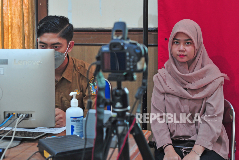 Petugas melayani warga yang melakukan perekaman foto untuk pembuatan Kartu Tanda Penduduk Elektronik (e-KTP)