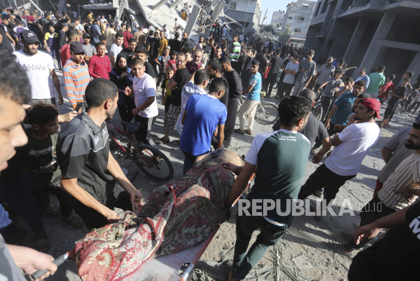 Warga Palestina mengevakuasi korban selamat pascaserangan udara Israel di Rafah, Jalur Gaza, Kamis, (26/10/2023).