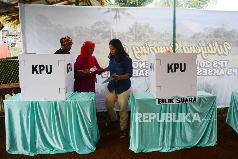 Pemilih tuna netra dibimbing oleh petugas tempat pemungutan suara (TPS). KPU DKI Jakarta memastikan TPS akan ramah terhadap kelompok disabilitas.