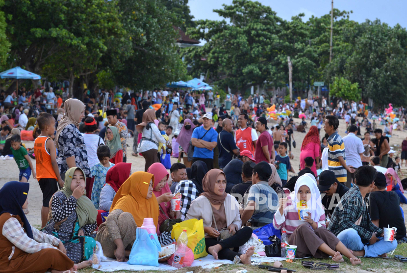 Warga mengunjungi Pantai Sanur saat tradisi Lebaran Ketupat di  Denpasar, Bali, Rabu (17/4/2024). Tradisi lebaran ketupat yang dirayakan ribuan umat muslim di kawasan itu pada hari ketujuh setelah Hari Raya Idul Fitri dilakukan sebagai ajang untuk saling bersilaturahmi. 