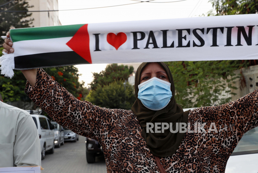 Seorang wanita mengenakan masker saat melakukan protes terhadap perjanjian normalisasi Uni Emirat Arab dan Bahrain dengan Israel, di depan kantor Koordinator Khusus PBB untuk Kantor Proses Perdamaian Timur Tengah di Kota Gaza, Selasa, 15 September 2020 Israel akan menandatangani perjanjian dengan UEA dan Bahrain di Gedung Putih pada hari Selasa. 