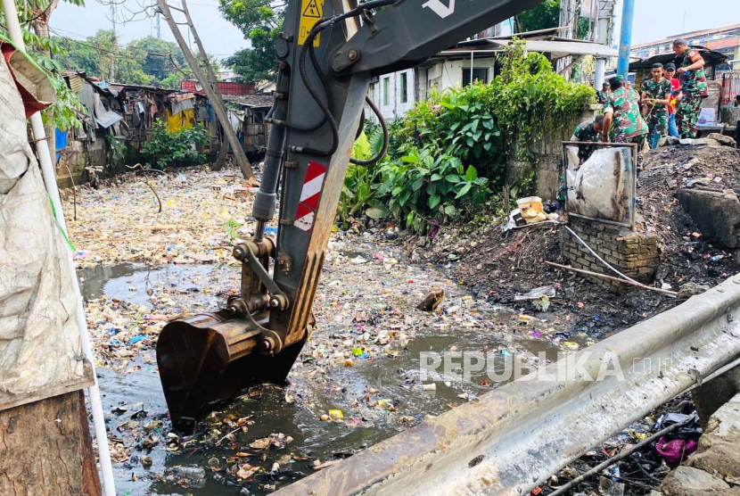Alat berat mengeruk sampah yang menumpuk di saluran air kawasan Simpang Ciawi, Kabupaten Bogor, Jawa Barat, Selasa (7/11/2023),