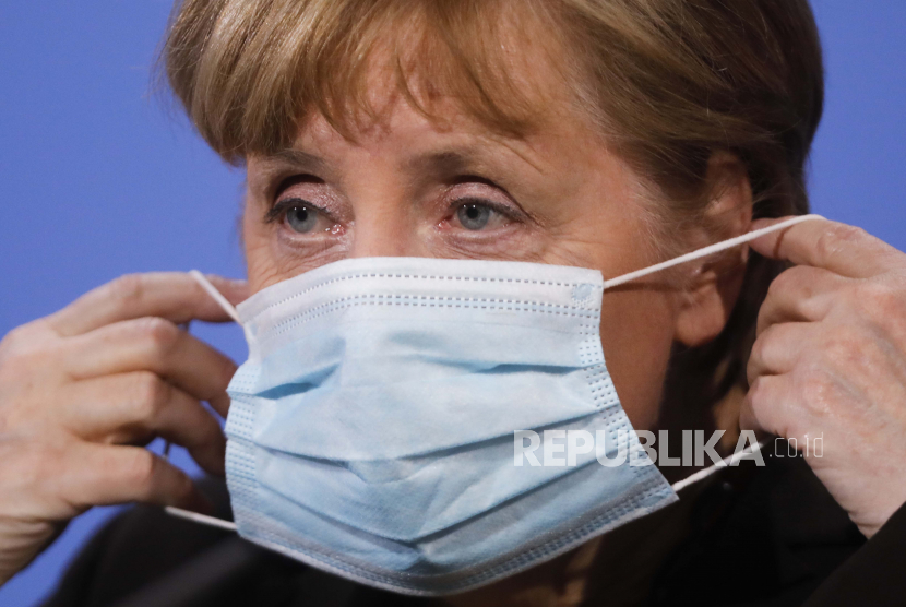 Kanselir Jerman Angela Merkel memakai masker wajahnya setelah dia memberi pengarahan kepada media setelah pertemuan virtual dengan gubernur negara bagian federal di kanselir di Berlin, Jerman, Selasa, 30 Maret 2021. Pejabat kesehatan Jerman pada Selasa setuju untuk membatasi penggunaan vaksin virus korona AstraZeneca. pada orang di bawah 60 tahun di tengah kekhawatiran baru atas pembekuan darah yang tidak biasa yang dilaporkan dari mereka yang menerima suntikan.