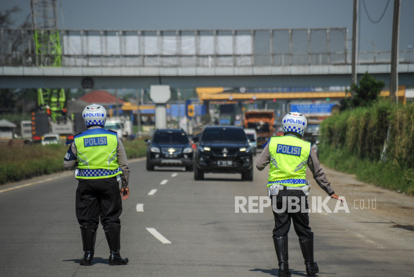 Petugas gabungan memberhentikan kendaraan untuk memeriksa kelengkapan surat dari pengendara dengan kendaraan nomor polisi luar Bandung di gerbang keluar Tol Cileunyi, Kabupaten Bandung, Jawa Barat, Ahad (25/4).