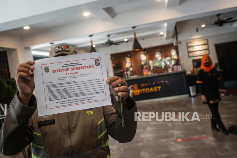 Petugas Satpol PP menutup restoran yang menyediakan layanan makan di tempat saat razia PSBB Jakarta di kawasan Sunter Agung, Jakarta, Kamis (24/9/2020). Polri mencatat hingga 22 September 2019, tim gabungan operasi yustisi telah melaksanakan penindakan dengan sanksi denda administrasi sebanyak 14.206 kali dengan nilai denda mencapai Rp1,055 miliar.