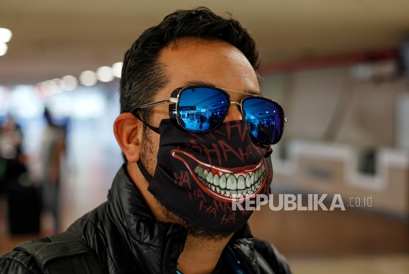 Seorang pria  mengenakan masker di  Arturo Merino Benitez International Airport, Santiago, Cili.