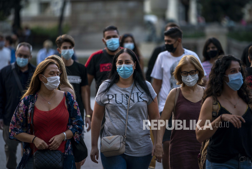 Sejumlah orang dengan memakai masker wajah untuk mencegah Covid-19 berjalan di pusat kota Barcelona, Spanyol, Rabu, (23/9). Menghadapi varian Omicron, Spanyol perketat syarat masuk bagi warga Inggris.
