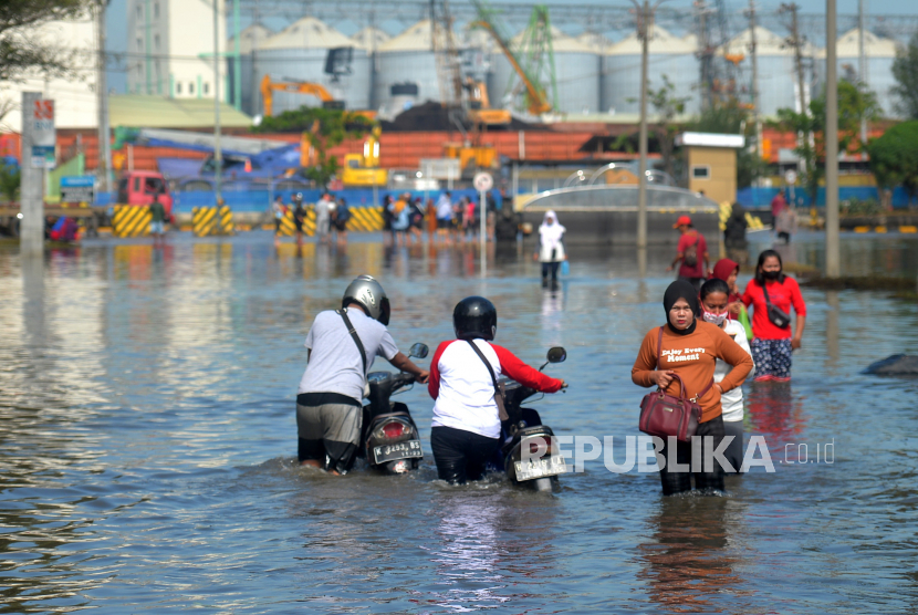 Pekerja pelabuhan menerobos banjir rob di dalam Pelabuhan Tanjung Emas, Semarang, Jawa Tengah, ilustrasi. 