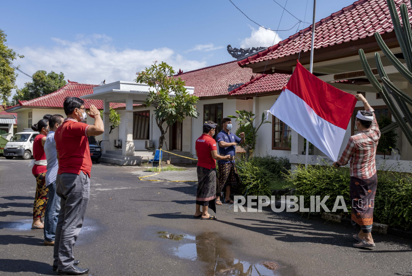 Petugas kesehatan mengibarkan bendera Indonesia saat upacara memperingati hari kemerdekaan Indonesia di fasilitas perawatan COVID-19 di Kuta, Bali, Indonesia, 17 Agustus 2021. 
