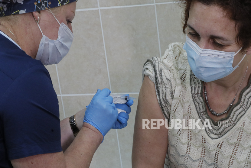  Seorang pekerja medis Rusia memberikan vaksin uji coba terhadap COVID-19 kepada seorang sukarelawan dalam fase tes pasca pendaftaran di rumah sakit rawat jalan nomor 68 di Moskow, Rusia, 17 September 2020. Rusia mendaftarkan vaksin baru yang disebut 