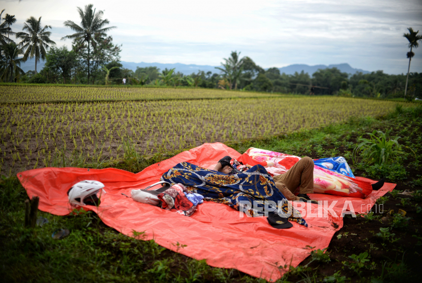 Pengungsi beristirahat di area pesawahan di Desa Gasol, Kecamatan Cugenang, Kabupaten Cianjur, Jawa Barat, Jumat (25/11/2022). 