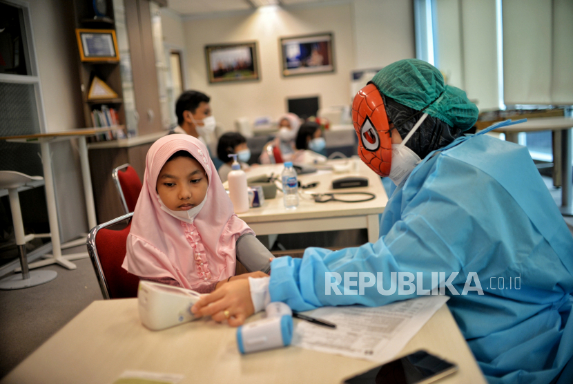 Pengguna ICU di RS Jakarta Naik 5 Persen dalam waktur empat hari saja. Foto tenaga kesehatan menggunakan topeng pahlawan super (superhero) memeriksa kesehatan sebelum menyuntikan vaksin covid-19 kepada anak usia 6-1, di Jakarta, Ahad (16/1/2022). -ilustrasi-