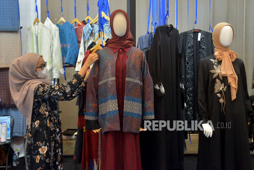 Karyawan menata koleksi busana muslim yang dipamerkan pada Jakarta Muslim Fashion Week (JMFW) tahun lalu. 