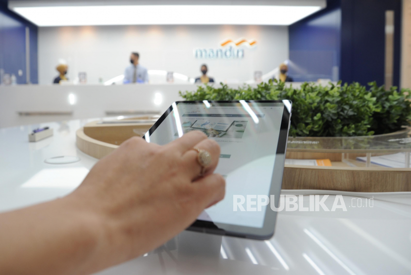 Nasabah mencoba salah satu aplikasi digital Bank Mandiri saat  pembukaan Kantor Cabang Pembantu (KCP) Menara Astra di Jakarta, Kamis (9/7). PT Bank Mandiri (Persero) Tbk optimistis laju pertumbuhan kredit sindikasi akan terus mengalami peningkatan.