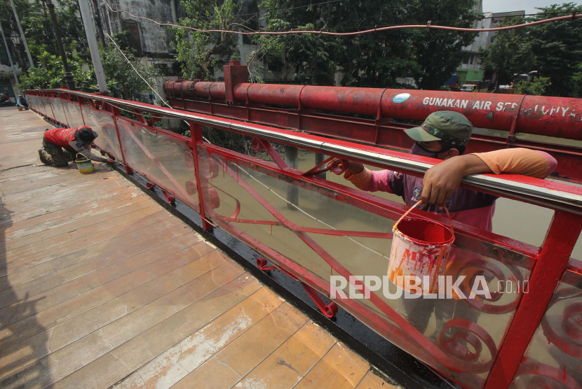 Pekerja mengecat Jembatan Merah, di Surabaya, Jawa Timur, Senin (15/3/2021). Pengecatan bangunan cagar budaya yang dibangun pada tahun 1809 tersebut agar tetap terawat.
