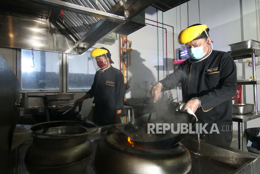 Koki memasak dengan menggunakan Alat Pelindung Diri (APD) di salah satu hotel di Banyuwangi, Jawa Timur, Jumat (12/6/2020). Sejumlah hotel di daerah itu mulai menerapkan protokol kesehatan COVID-19 guna mempersiapkan tatanan normal baru