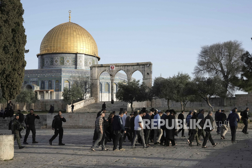  Polisi Israel mengawal pengunjung Yahudi yang menandai hari raya Paskah ke kompleks Masjid Al-Aqsa, yang dikenal oleh umat Islam sebagai Tempat Suci Mulia dan bagi orang Yahudi sebagai Temple Mount, menyusul penggerebekan semalam di situs tersebut, di Kota Tua Yerusalem pada  bulan suci Ramadhan, Rabu (5/4/2023) .