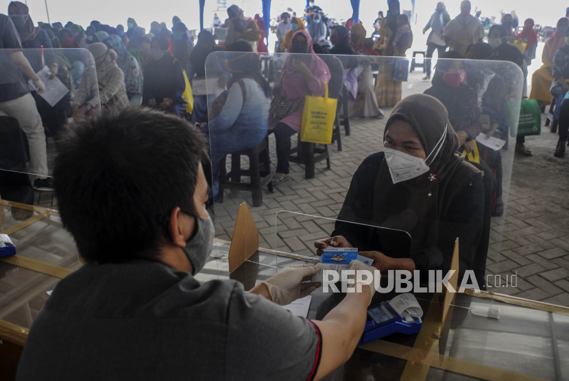 Petugas memberikan Kartu ATM Bank DKI dan buku rekening untuk orang tua dari anak penerima Kartu Jakarta Pintar (KJP) saat penyaluran KJP Plus tahap dua di kawasan Matraman, Jakarta Timur, Rabu (24/11/2021). 