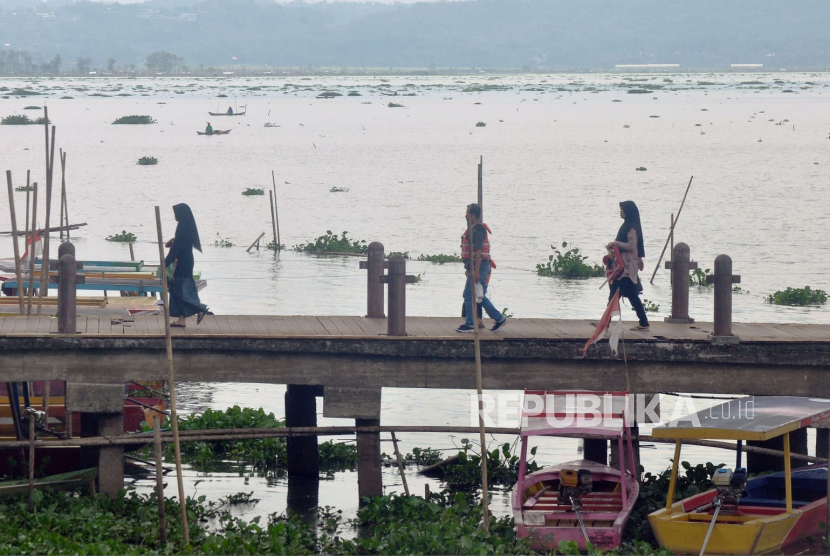 Permukaan danau Rawapening dan dermaga DTW Bukit Cinta Rawapening di wilayah Desa Kebondowo, Kecamatan Banyubiru, Kabupaten Semarang tampak tertutup kembali oleh rumpun- rumpun enceng gondok yang terbawa angin, Selasa (27/6/2023).