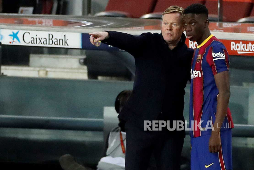  Pelatih kepala FC Barcelona Ronald Koeman (kiri) memberikan instruksi kepada gelandang Ilaix Moriba.