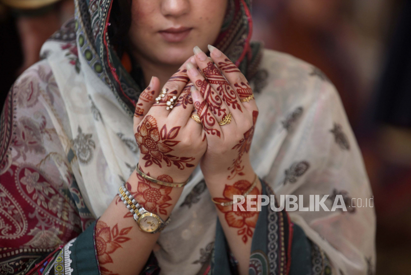  Seorang wanita Muslim dengan tangannya yang dilukis dengan pacar tradisional berdoa selama sholat Idul Fitri, membuat pada akhir bulan puasa Ramadhan, di Masjid Badshahi yang bersejarah di Lahore, Pakistan, Selasa, 3 Mei 2022. Ilustrasi berdoa