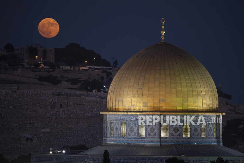 The super moon rises behind the Dome of the Rock shrine at the Al Aqsa Mosque compound in the Old City of Jerusalem, Monday, Aug. 19, 2024. 