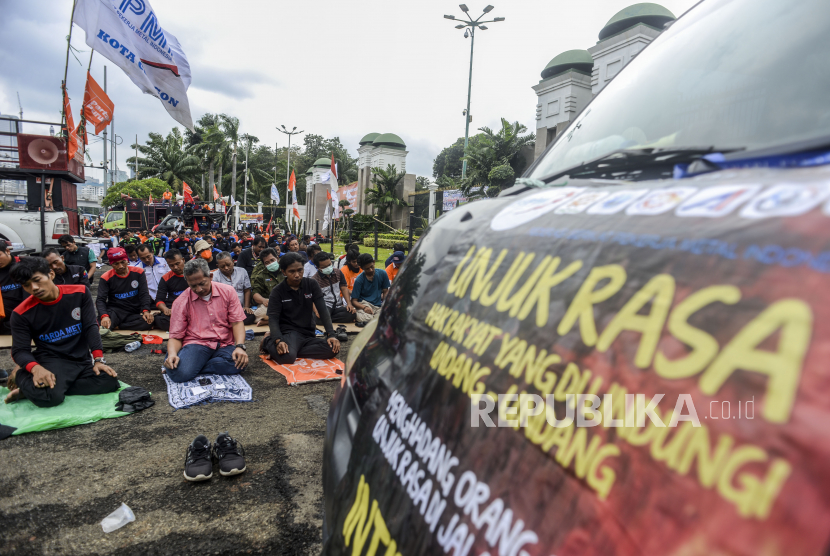 Sejumlah massa buruh melaksanakan Shalat Jumat disela aksi di depan Gedung DPR, Jakarta, Jumat (14/1/2022). Aksi tersebut menuntut dihentikannya pembahasan UU Omnibus Law Cipta Kerja yang direncanakan oleh DPR untuk dimasukan ke dalam Program Legilasi Nasional (Prolegnas) Prioritas 2022. Republika/Putra M. Akbar
