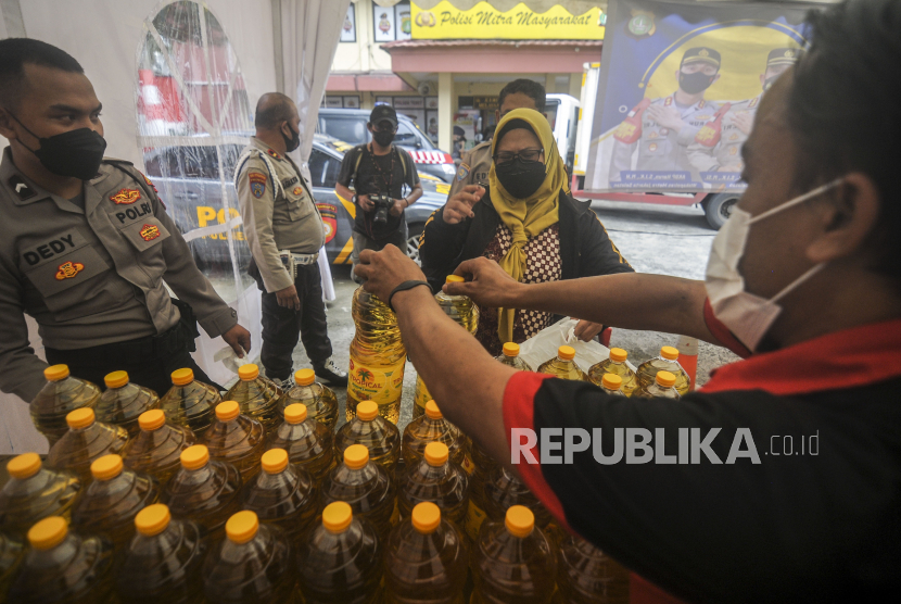 Warga membeli minyak goreng saat operasi pasar di Polsek Tebet, Jakarta, Jumat (4/3/2022).