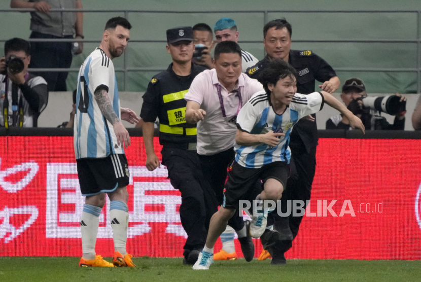 Seorang penggemar Lionel Messi berlari ke lapangan setelah memeluk superstar sepak itu (kiri) saat pertandingan sepak bola persahabatan melawan Australia di Beijing, Kamis, (15/6/2023).