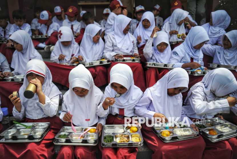 Para siswa menyantap hidangan Makan Bergizi Gratis (MBG) di SDN 05 Sukatani, Depok, Jawa Barat, Senin (6/1/2025). Pada hari pertama program makan bergizi gratis (MBG) tersebut para siswa terlihat antusias menikmati menu makanan. Total sebanyak 406 para siswa kelas 1 hingga kelas 6 menikmati paket menu makanan uang teridiri dari Nasi, Daging Ayam, Tempe, Sayur Buncis dan Buah Jeruk. Salah satu siswa kelas 5 Fatah Ar Rozak mengaku senang mendapatkan makan bergizi gratis dari program pemerintah tersebut. Menurutnya rasa makanannya enak dan untuk porsi makanannya cukup mengenyangkan.