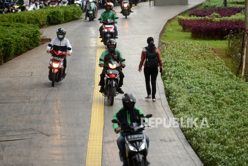 Pengendara motor melintas di jalur pedestrian di Kawasan MT Haryono, Cawang, Jakarta, Kamis (2/2/2023). Para pengendara sepeda motor melakukan pelanggaran disiplin lalu lintas dengan menggunakan trotoar sebagai jalurnya dan mengambil hak para pejalan kaki untuk menghidari kemacetan lalulintas. 