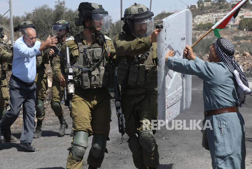 Pemrotes Palestina berdebat dengan pasukan Israel selama bentrokan setelah demonstrasi menentang pemukiman Israel di tanah desa Kafr Qadoum, dekat kota Nablus, Tepi Barat, 23 September 2022. Israel Kirimkan 18 Perintah Penghentian Pembangunan Rumah Warga Palestina