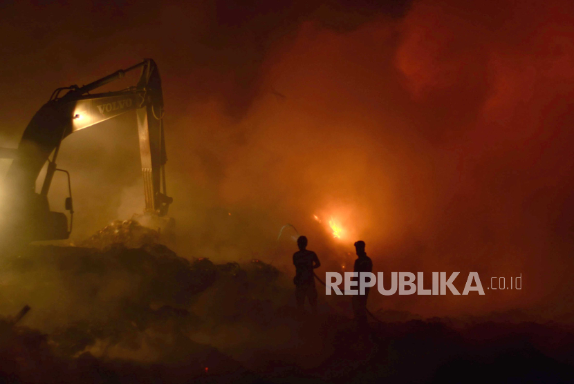 Petugas pemadam kebakaran menyemprotkan air di tumpukan sampah yang terbakar di Tempat Pembuangan Akhir (TPA) Bakung, Bandar Lampung, Lampung.